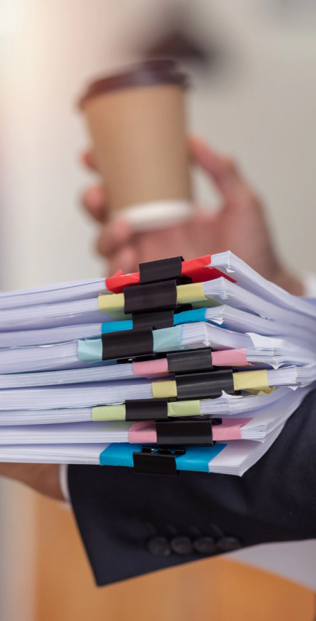 woman holding coffee and paperwork